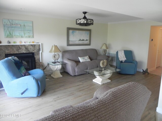 living room featuring ornamental molding, a premium fireplace, and hardwood / wood-style floors