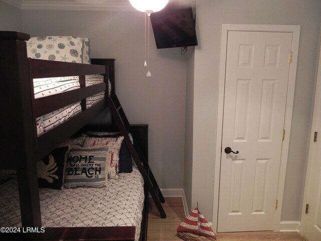 bedroom with ornamental molding and light hardwood / wood-style flooring