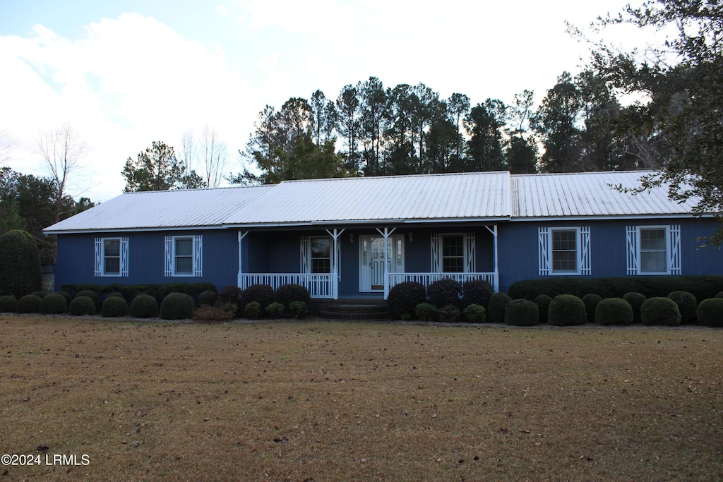 single story home with a front yard and covered porch