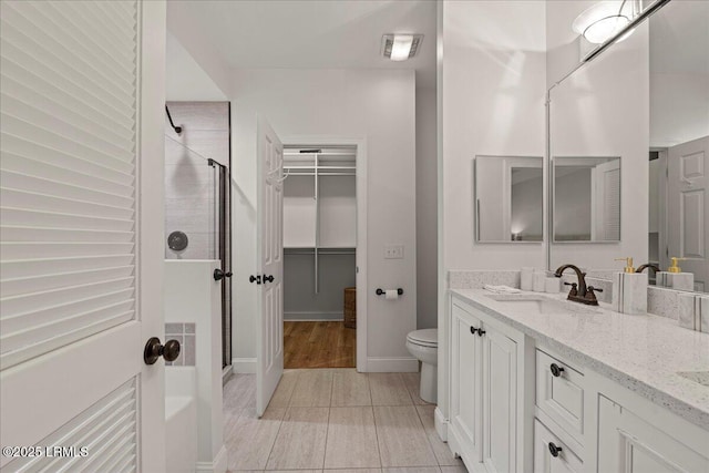 419 Bb Sams Dr, Saint Helena Island, SC 29920 - bathroom featuring a stall shower, vanity, toilet, a spacious closet, and baseboards