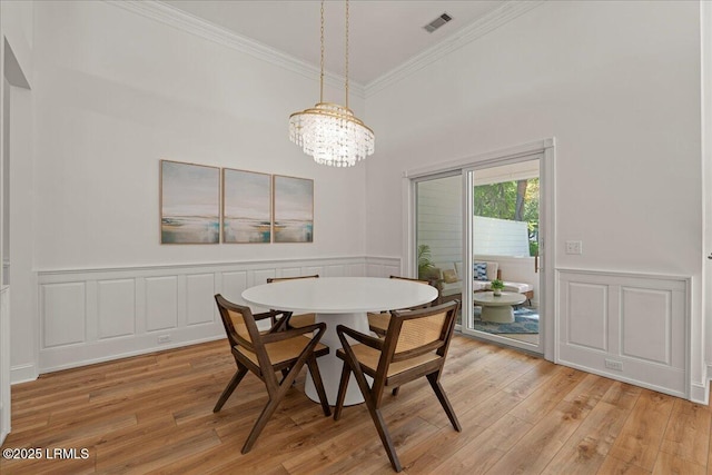 419 Bb Sams Dr, Saint Helena Island, SC 29920 - dining room with ornamental molding, a chandelier, light wood finished floors, a wainscoted wall, and a decorative wall