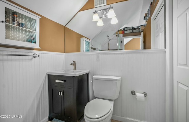 bathroom featuring vanity, lofted ceiling, and toilet