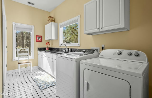 laundry area with cabinets, washing machine and dryer, and sink