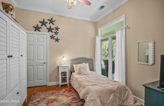 bedroom with ceiling fan, ornamental molding, and hardwood / wood-style floors