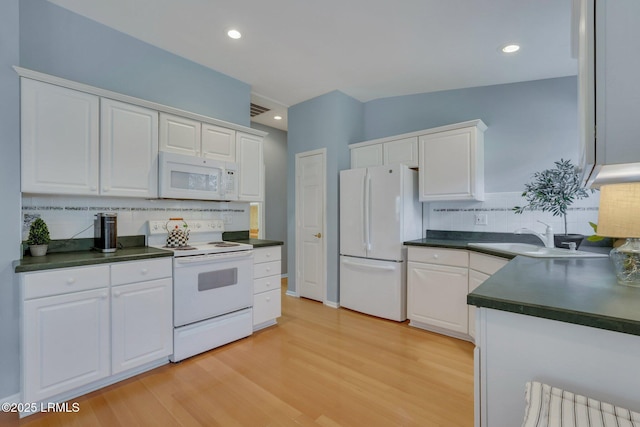 15 Padgett Dr, Bluffton, SC 29909 - kitchen with vaulted ceiling, white cabinetry, sink, light wood-type flooring, and white appliances