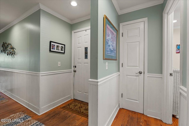 foyer with wainscoting, crown molding, and wood finished floors