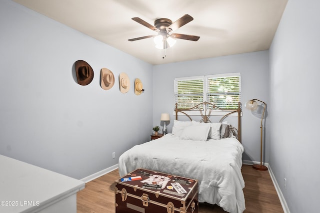 bedroom with wood finished floors, baseboards, and a ceiling fan