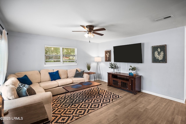 living room featuring a ceiling fan, wood finished floors, and baseboards