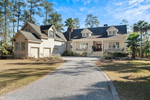 new england style home featuring a garage, a front yard, and covered porch