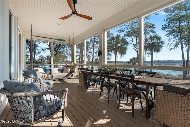 sunroom with a water view and ceiling fan