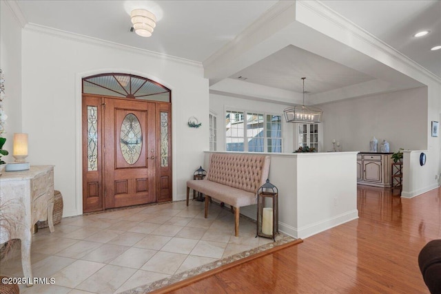 entryway with a notable chandelier, light hardwood / wood-style flooring, and ornamental molding