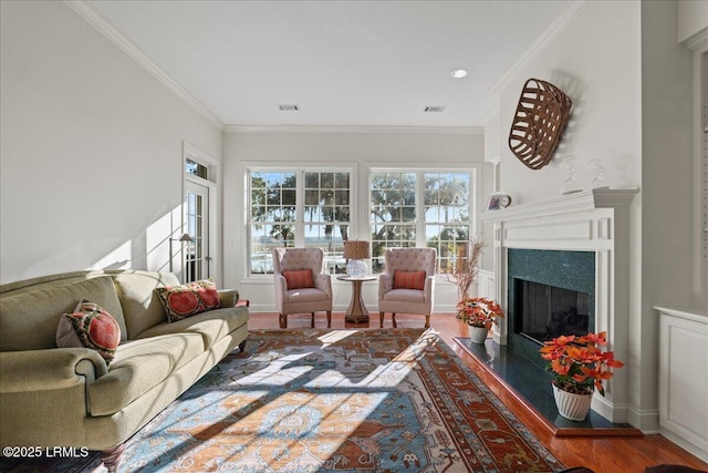 living room featuring hardwood / wood-style flooring, a fireplace, and ornamental molding