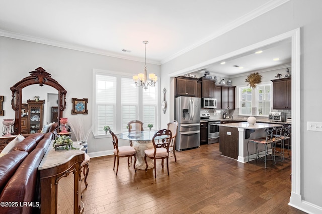 2712 Bluestem Dr, Beaufort, SC 29902 - dining area with a chandelier, a toaster, baseboards, ornamental molding, and dark wood-style floors