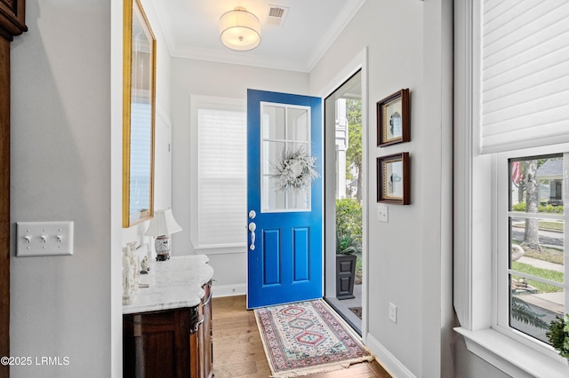 2712 Bluestem Dr, Beaufort, SC 29902 - entrance foyer with light wood-style flooring, visible vents, a wealth of natural light, and ornamental molding