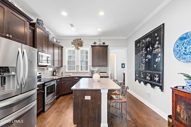 2712 Bluestem Dr, Beaufort, SC 29902 - kitchen featuring stainless steel appliances, dark wood finished floors, tasteful backsplash, visible vents, and a breakfast bar area