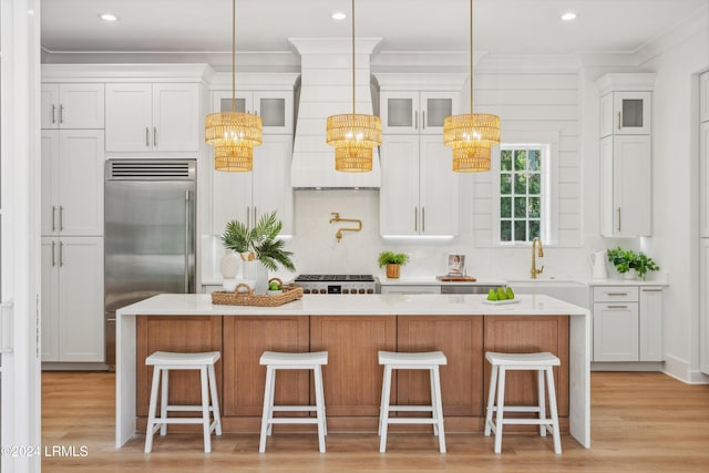 kitchen featuring a center island, sink, white cabinets, and stainless steel built in fridge