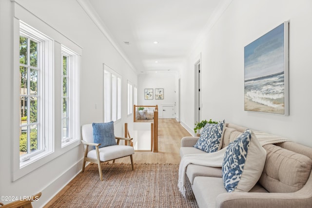 sitting room featuring crown molding, a healthy amount of sunlight, and hardwood / wood-style floors