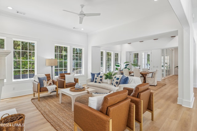 living room featuring french doors, ceiling fan, light hardwood / wood-style flooring, and a wealth of natural light