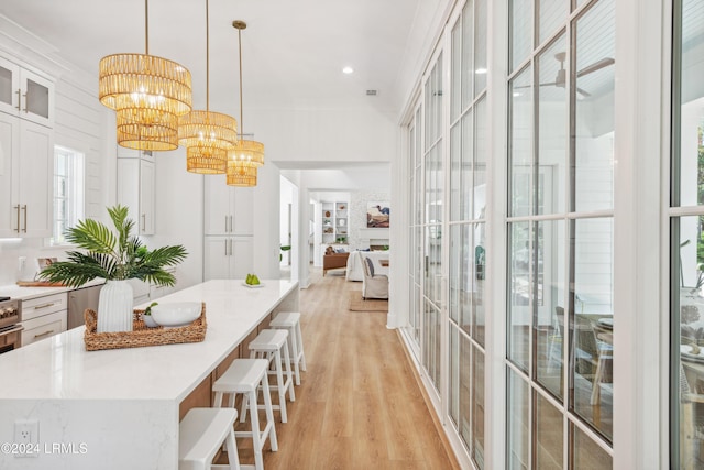 hallway with an inviting chandelier and light hardwood / wood-style flooring