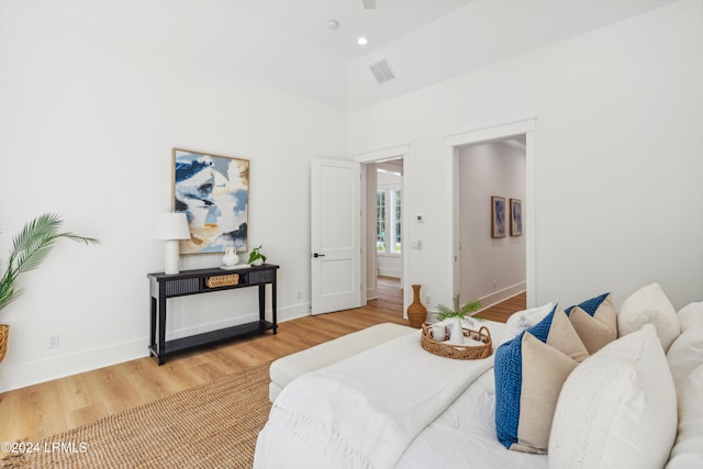 bedroom with wood-type flooring and high vaulted ceiling