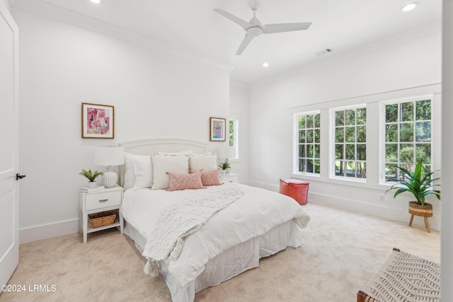 bedroom featuring light colored carpet, ornamental molding, and ceiling fan