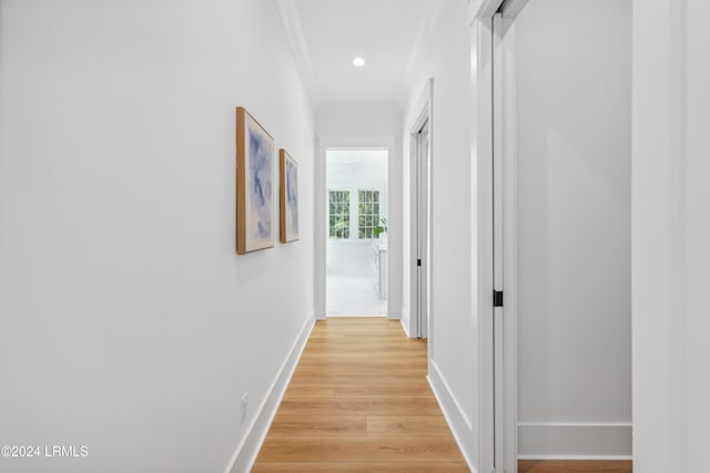 hallway with crown molding and light hardwood / wood-style floors