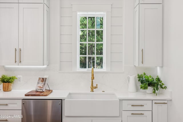 kitchen featuring white cabinetry, dishwashing machine, sink, and tasteful backsplash