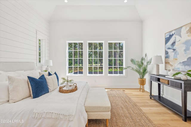 bedroom with vaulted ceiling and light wood-type flooring