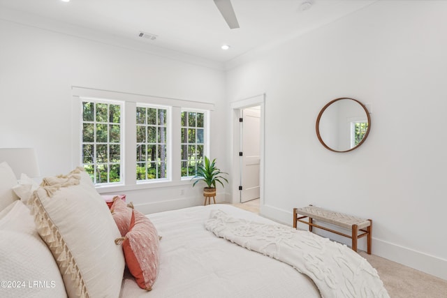 carpeted bedroom with crown molding and ceiling fan