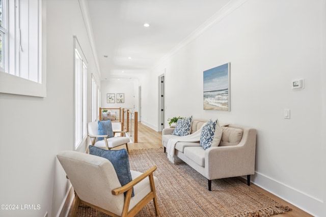 living area with crown molding and wood-type flooring