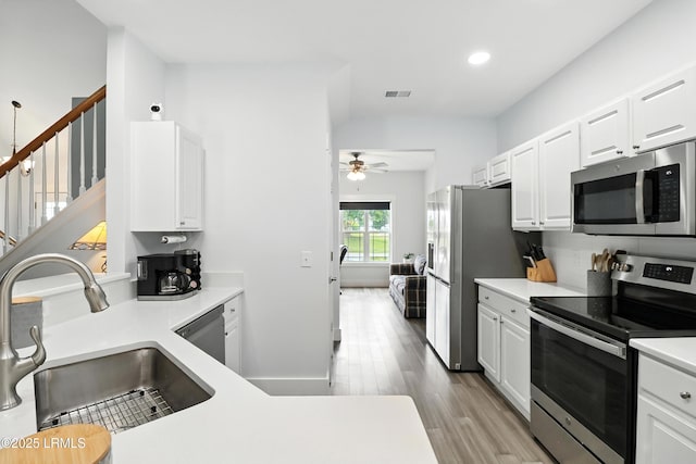 1 Broadland Cir, Bluffton, SC 29910 - kitchen featuring stainless steel appliances, a ceiling fan, white cabinetry, wood finished floors, and light countertops