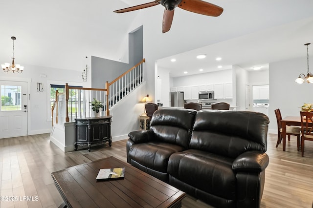 1 Broadland Cir, Bluffton, SC 29910 - living room featuring a chandelier, high vaulted ceiling, light wood finished floors, stairs, and ceiling fan