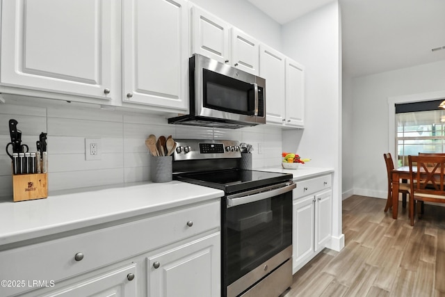 1 Broadland Cir, Bluffton, SC 29910 - kitchen featuring stainless steel appliances, tasteful backsplash, white cabinetry, light wood-type flooring, and light countertops