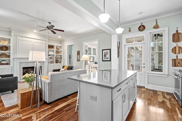 kitchen featuring dark wood-style flooring, decorative light fixtures, light countertops, open floor plan, and a kitchen island