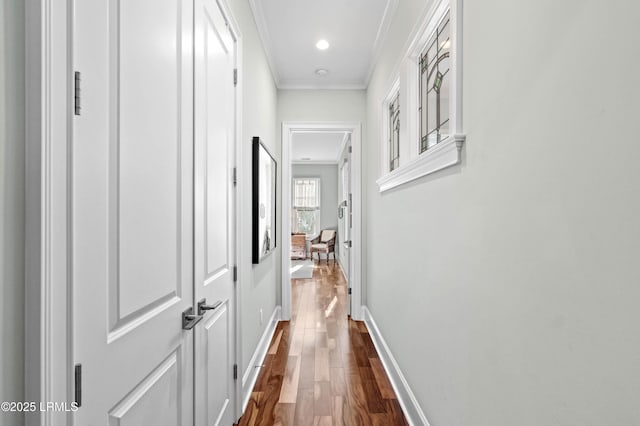 hall with dark wood-style floors, recessed lighting, ornamental molding, and baseboards