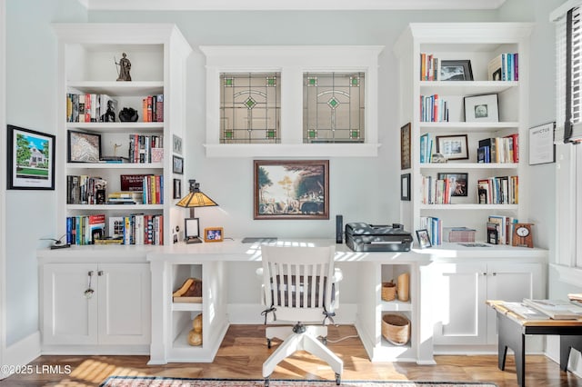 sitting room featuring light wood-type flooring and built in features