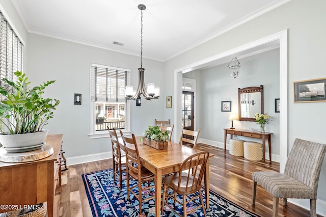 dining area featuring a wealth of natural light, wood finished floors, visible vents, and an inviting chandelier