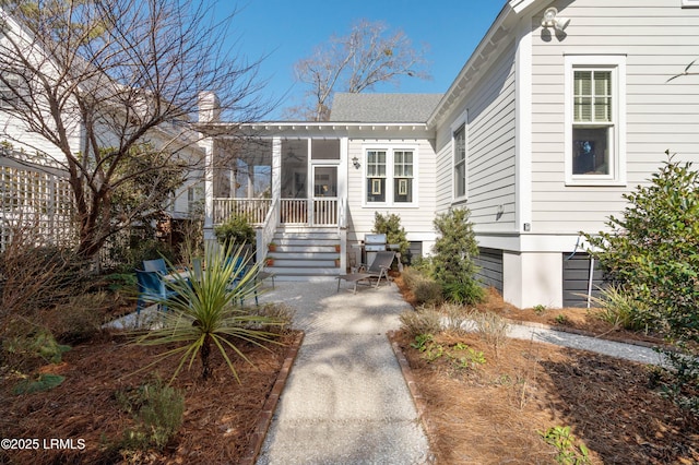 view of front of property with a sunroom, a patio area, and a chimney