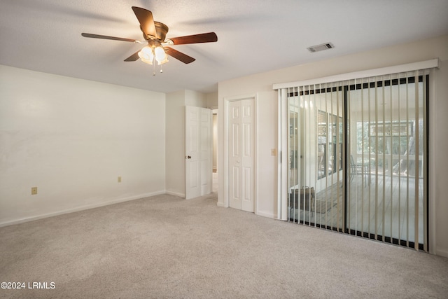 spare room featuring ceiling fan and carpet