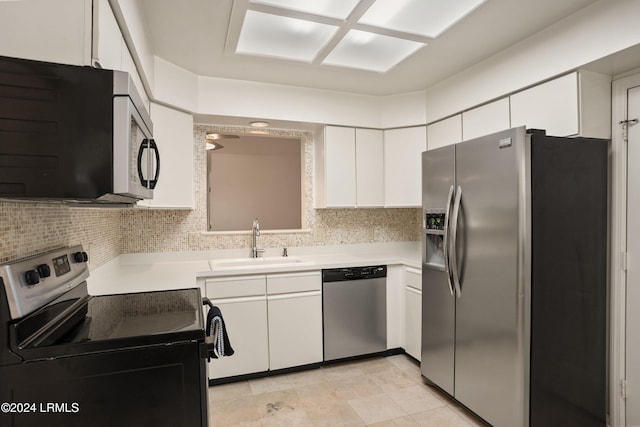 kitchen with tasteful backsplash, sink, stainless steel appliances, and white cabinets