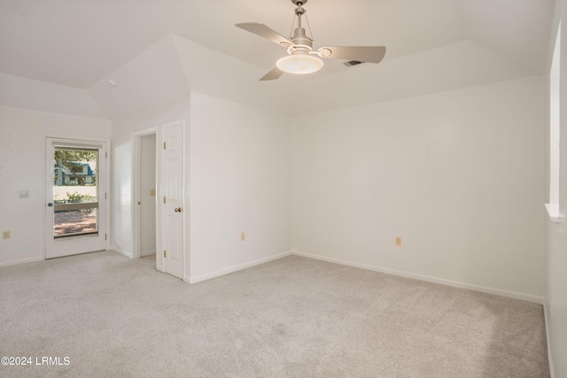 spare room featuring lofted ceiling, light colored carpet, and ceiling fan