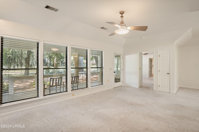 spare room with lofted ceiling, light carpet, and ceiling fan