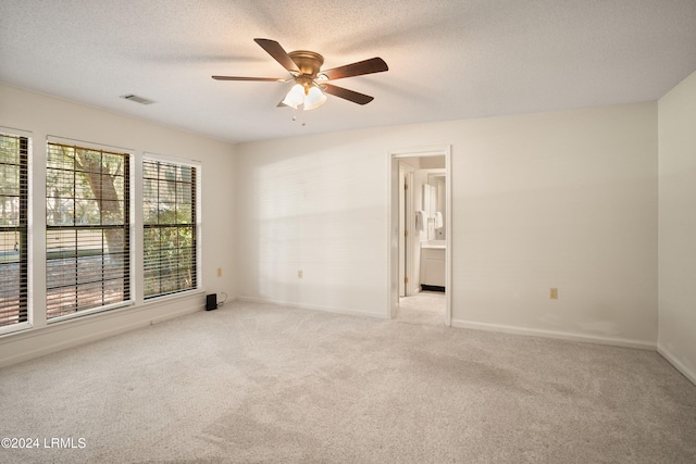 carpeted empty room featuring ceiling fan and a textured ceiling