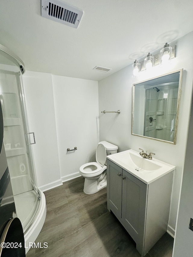 bathroom featuring vanity, hardwood / wood-style flooring, toilet, and walk in shower