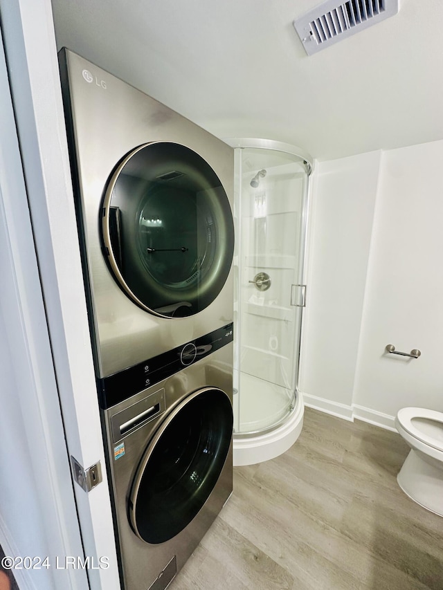 washroom featuring stacked washer and dryer and hardwood / wood-style flooring