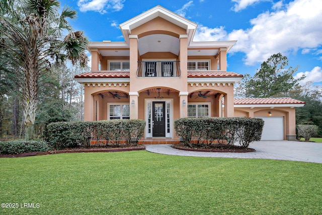 view of front of property featuring a garage, a balcony, and a front lawn