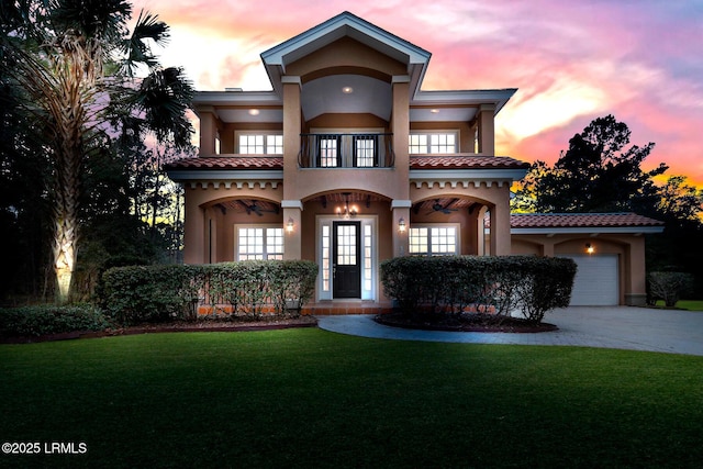 view of front of property with a garage, a balcony, and a yard