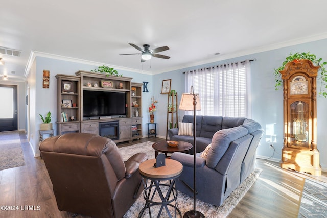 living room with hardwood / wood-style flooring, ornamental molding, and ceiling fan