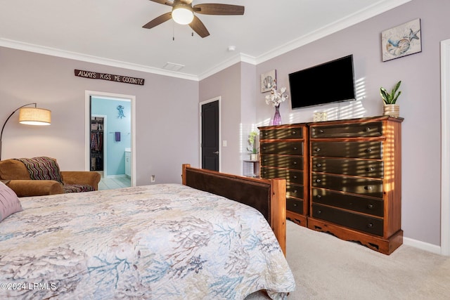 carpeted bedroom featuring ceiling fan, crown molding, and ensuite bath