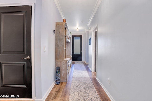 hallway with crown molding and light hardwood / wood-style flooring